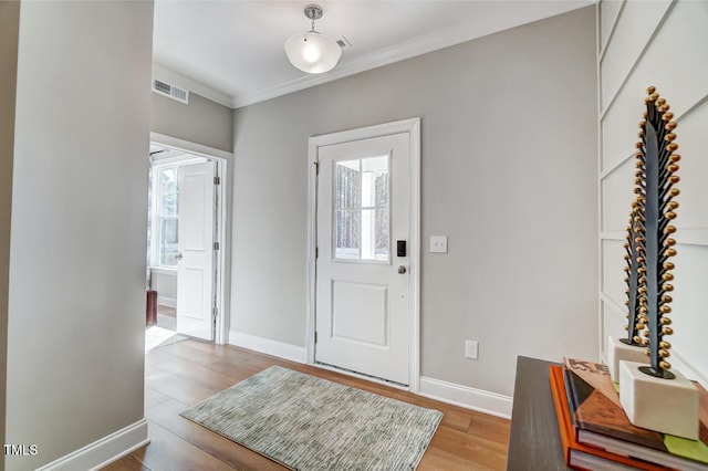 entrance foyer with hardwood / wood-style flooring and crown molding