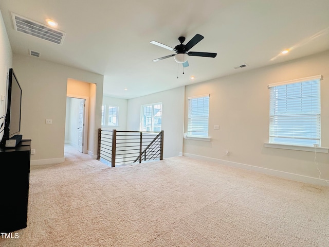 carpeted spare room featuring ceiling fan