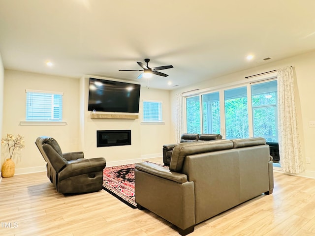 living room featuring ceiling fan and light hardwood / wood-style flooring