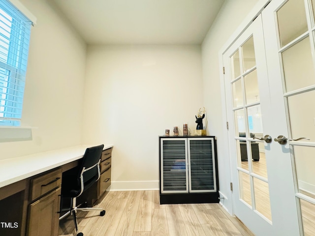 office area with beverage cooler, light hardwood / wood-style flooring, and french doors