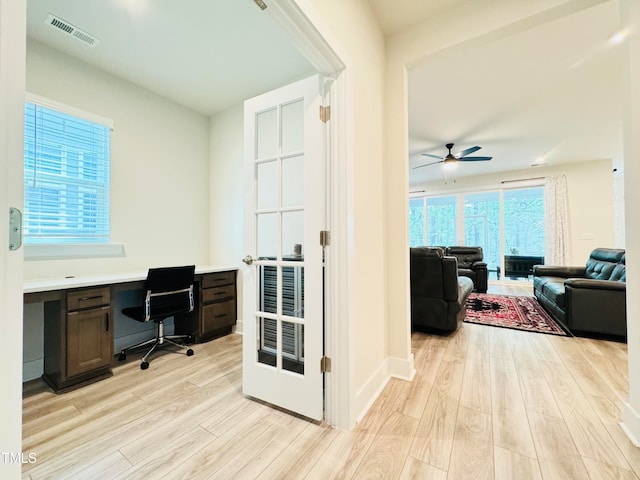 office area featuring light hardwood / wood-style floors, a wealth of natural light, and built in desk