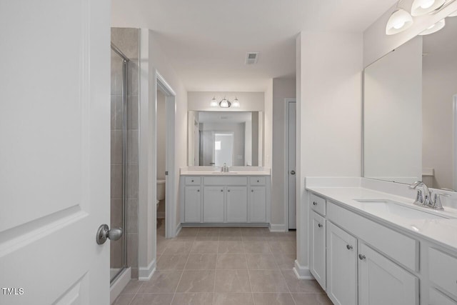 bathroom with vanity, toilet, tile patterned floors, and an enclosed shower