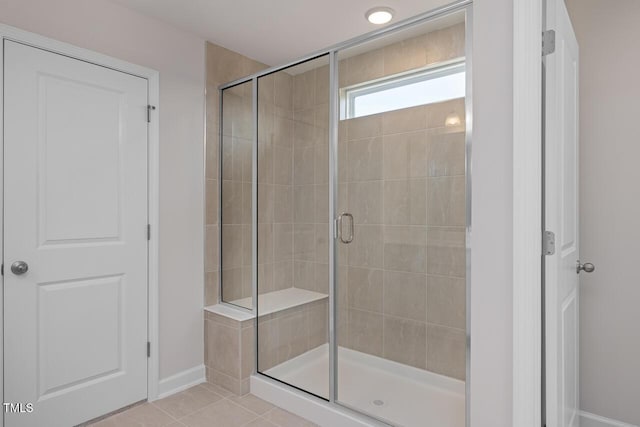 bathroom featuring a shower with shower door and tile patterned flooring