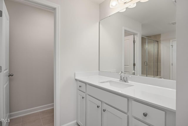 bathroom featuring walk in shower, vanity, and tile patterned flooring