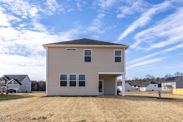 rear view of property featuring a yard