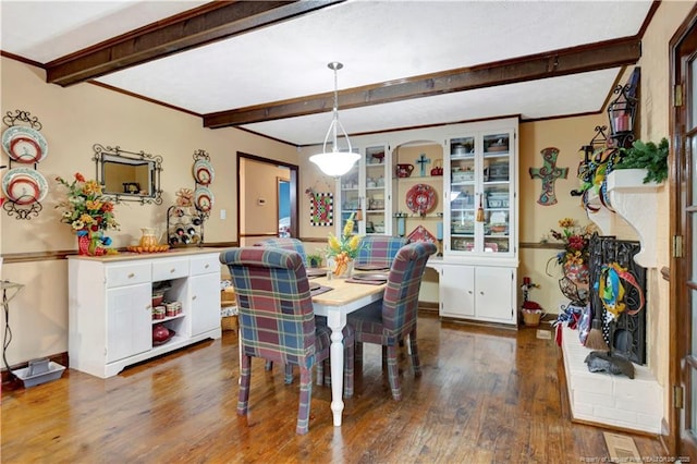 dining area featuring beamed ceiling and dark hardwood / wood-style flooring