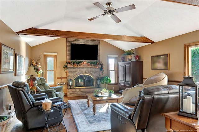 living room featuring lofted ceiling with beams, ceiling fan, wood-type flooring, and a fireplace