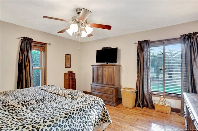 bedroom with multiple windows, ceiling fan, and light wood-type flooring