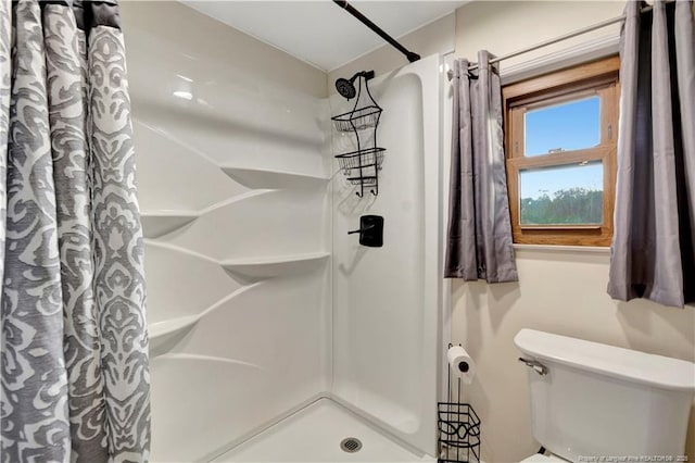 bathroom featuring a shower with shower curtain and toilet