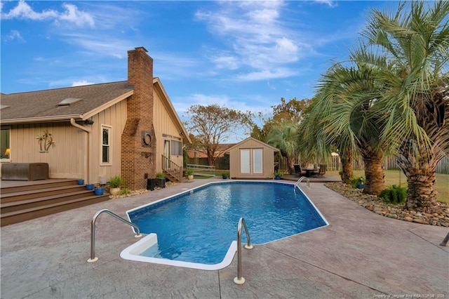 view of pool with a shed, a deck, and a patio