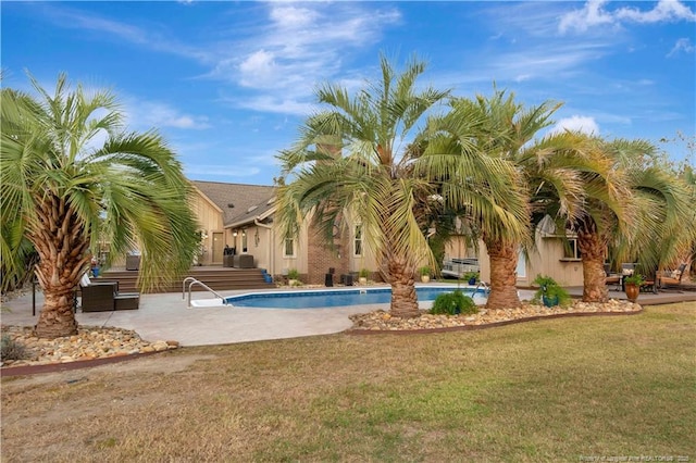 view of pool featuring a yard and a patio