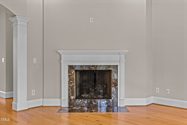 interior details with ornate columns, wood-type flooring, and a high end fireplace