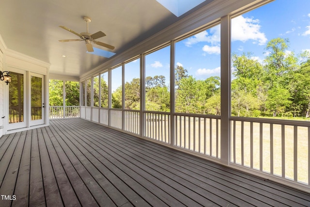 unfurnished sunroom with ceiling fan, plenty of natural light, and a skylight