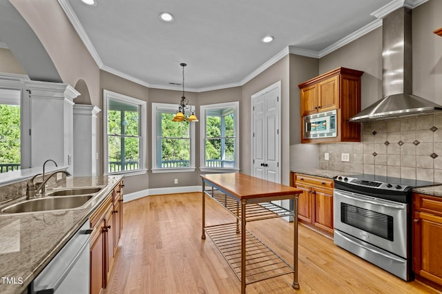 kitchen with stainless steel appliances, wall chimney exhaust hood, sink, and light hardwood / wood-style flooring