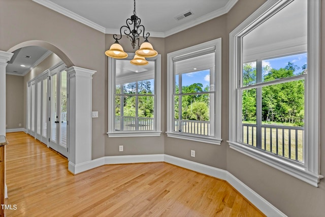 unfurnished dining area featuring a wealth of natural light, a notable chandelier, and light hardwood / wood-style flooring