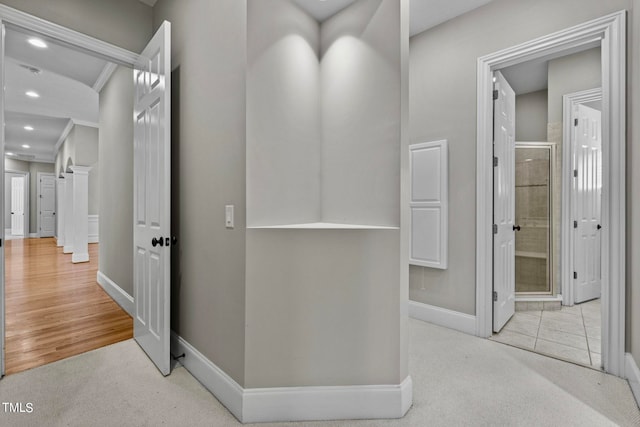 corridor featuring light hardwood / wood-style flooring and crown molding