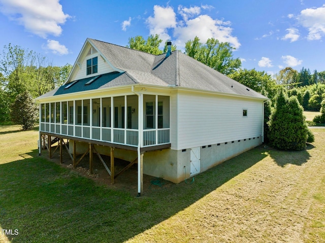 rear view of house with a sunroom and a lawn