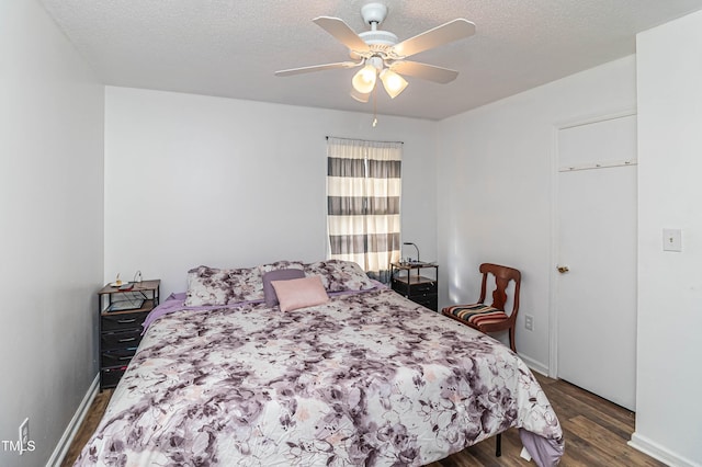 bedroom featuring a textured ceiling, ceiling fan, and dark hardwood / wood-style floors