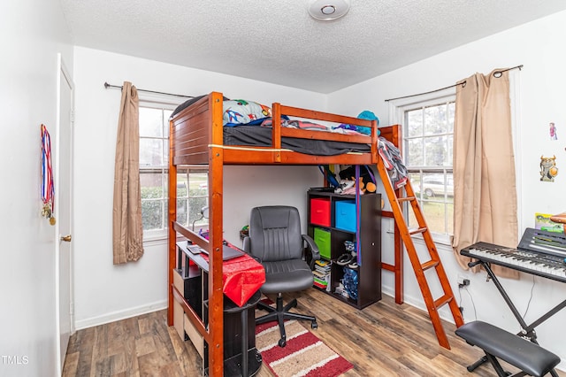 bedroom featuring wood-type flooring and a textured ceiling