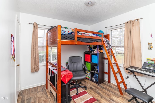 1717 Martin Luther King Dr, Rocky Mount, NC 27801 - bedroom with a textured ceiling, multiple windows, wood finished floors, and baseboards