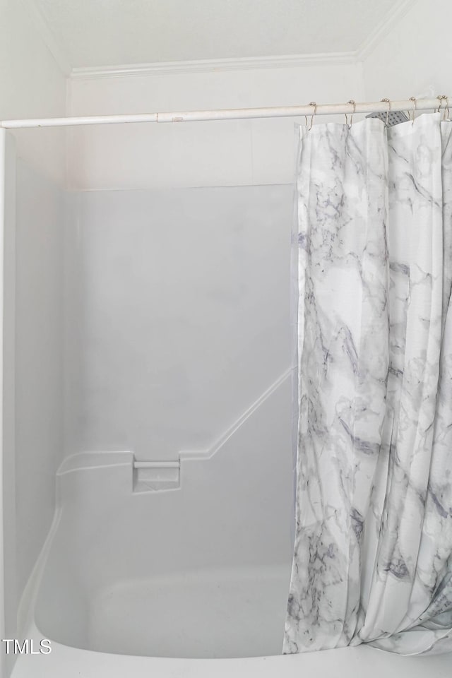 bathroom featuring a shower with shower curtain and crown molding