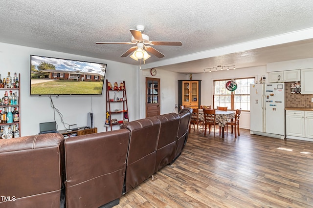 living room with hardwood / wood-style flooring, ceiling fan, and a textured ceiling