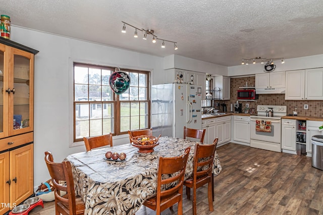 dining space featuring a textured ceiling, dark hardwood / wood-style flooring, and sink