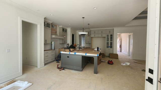 286 W Beech Slope Ct, Chapel Hill, NC 27517 - kitchen with custom exhaust hood, gray cabinetry, a kitchen island with sink, glass insert cabinets, and decorative light fixtures