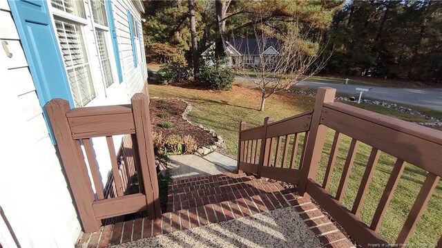 wooden terrace featuring a yard