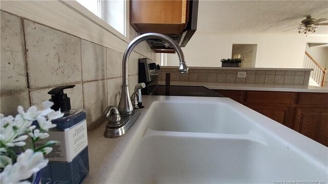 interior details featuring ceiling fan and sink