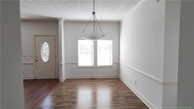 foyer entrance featuring a textured ceiling and dark hardwood / wood-style flooring