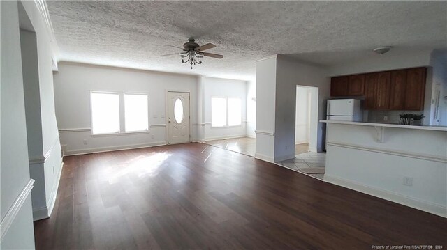 unfurnished living room with light hardwood / wood-style flooring, a textured ceiling, and ceiling fan