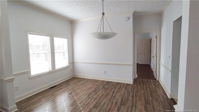 unfurnished dining area featuring a textured ceiling and dark hardwood / wood-style flooring