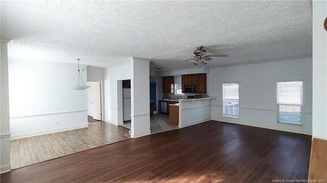 unfurnished living room featuring dark wood-type flooring, a textured ceiling, and ceiling fan