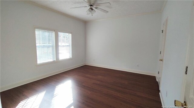 empty room with ceiling fan, dark hardwood / wood-style floors, and crown molding