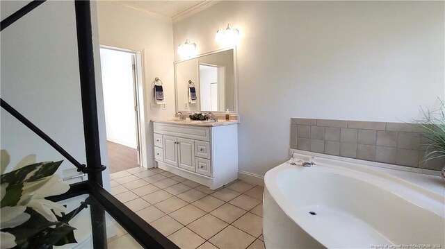 bathroom featuring ornamental molding, tile patterned flooring, vanity, and a bath