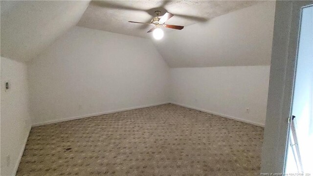 bonus room featuring carpet floors, a textured ceiling, ceiling fan, and vaulted ceiling