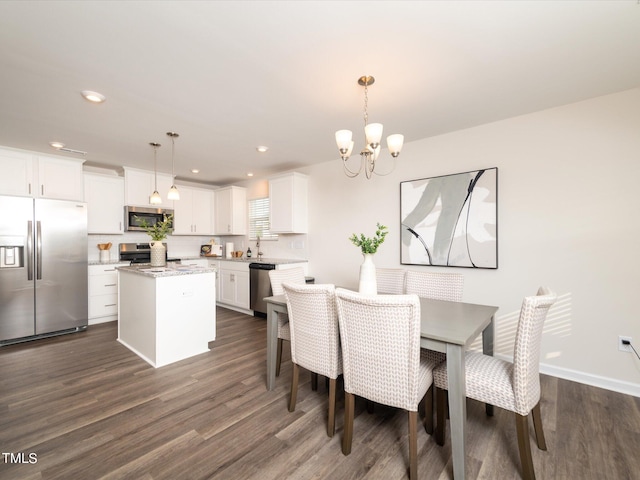 dining room with dark hardwood / wood-style flooring, sink, and a notable chandelier