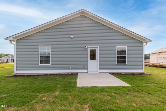 rear view of property featuring a lawn and a patio