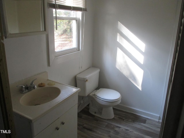 bathroom with hardwood / wood-style floors, vanity, and toilet