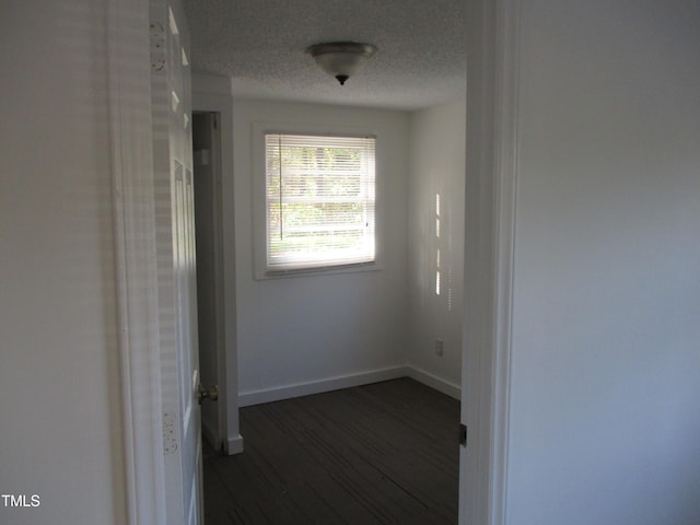 corridor featuring dark hardwood / wood-style flooring and a textured ceiling