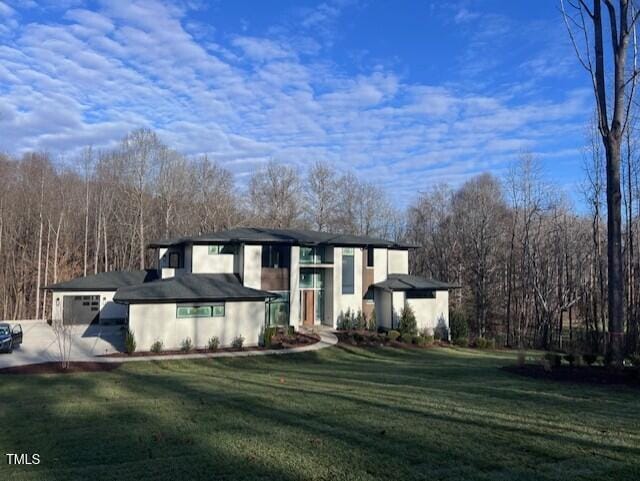 view of front of house featuring a garage and a front lawn