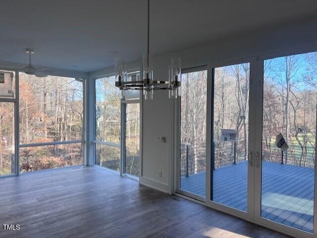 unfurnished dining area with hardwood / wood-style flooring and a chandelier