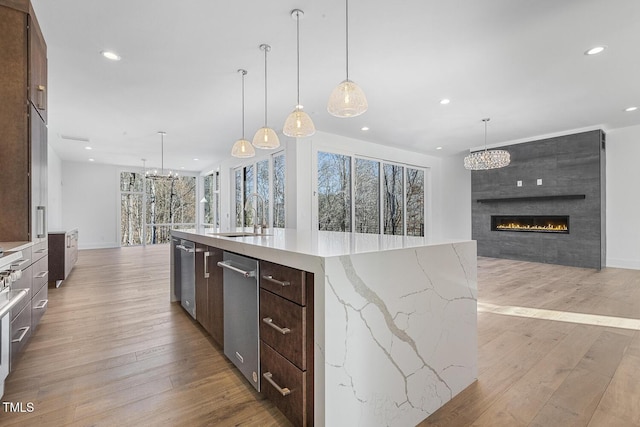 kitchen with pendant lighting, sink, and a large island with sink