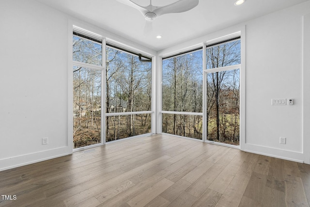 unfurnished sunroom with ceiling fan