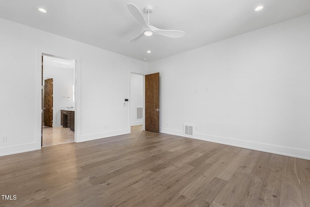 unfurnished bedroom with connected bathroom, ceiling fan, and light wood-type flooring