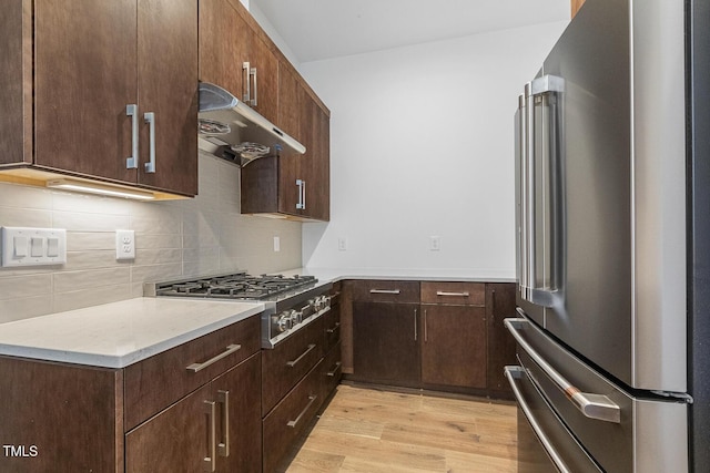 kitchen featuring dark brown cabinetry, light hardwood / wood-style flooring, and stainless steel appliances