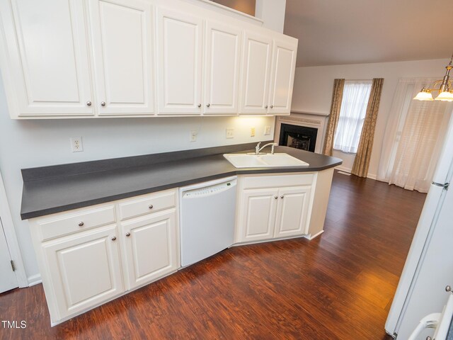 6220 Sweden Dr, Raleigh, NC 27612 - kitchen with white appliances, a sink, dark countertops, dark wood-style flooring, and white cabinetry