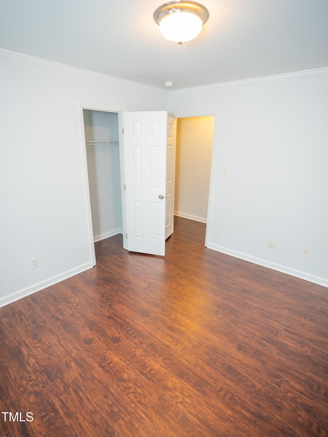 unfurnished bedroom with dark wood-type flooring, a closet, and ornamental molding