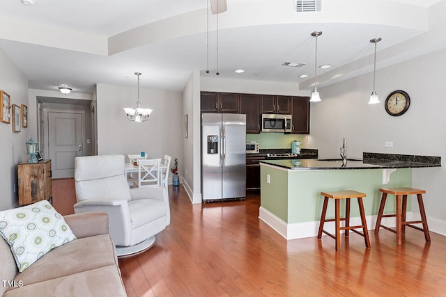 kitchen featuring appliances with stainless steel finishes, sink, pendant lighting, and hardwood / wood-style floors